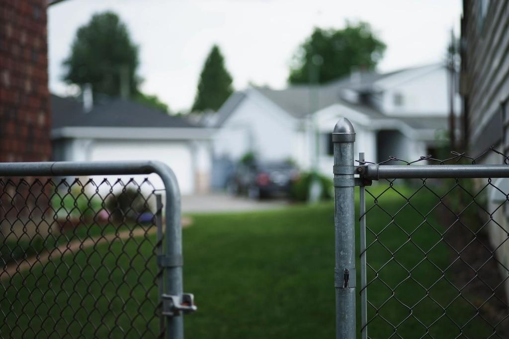 Residential chain link fence gate leading into a backyard, shown as a style example of chain link fencing